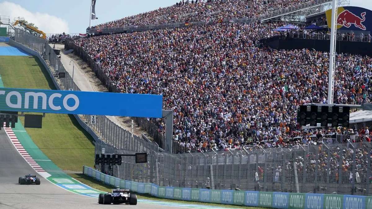 Cars climbing the steep run to Turn 1 with dramatic elevation change and heavy braking zone