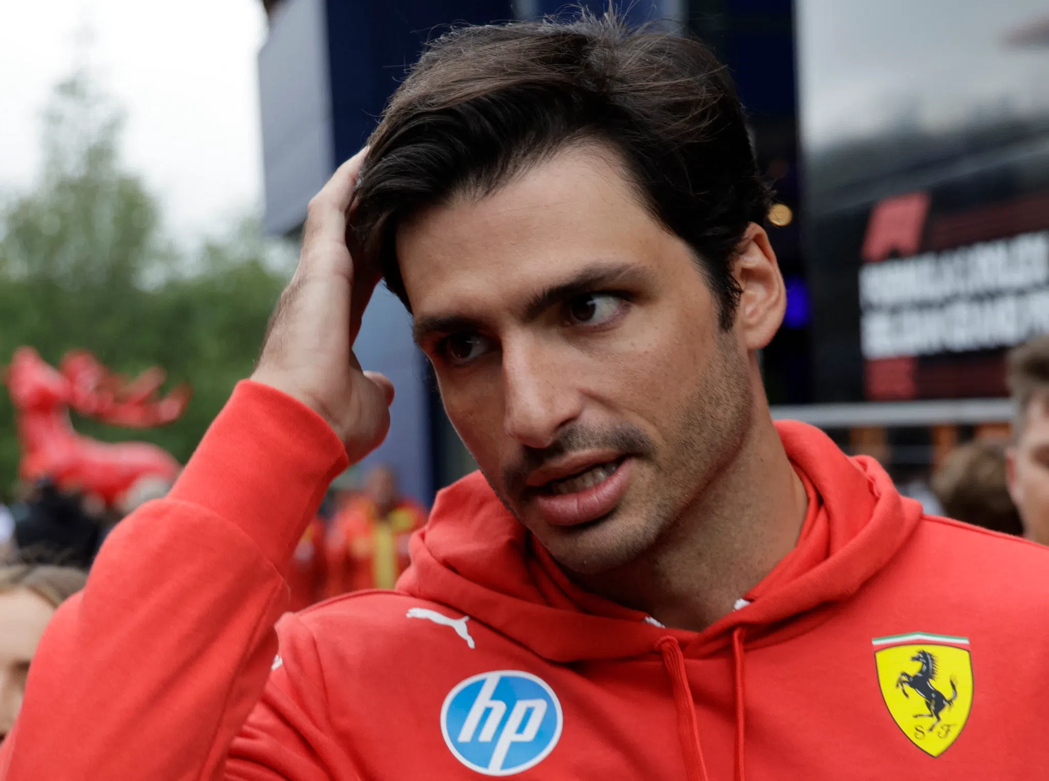 Carlos Sainz launching off the grid at a Formula 1 race start, wheel smoke and crowded field