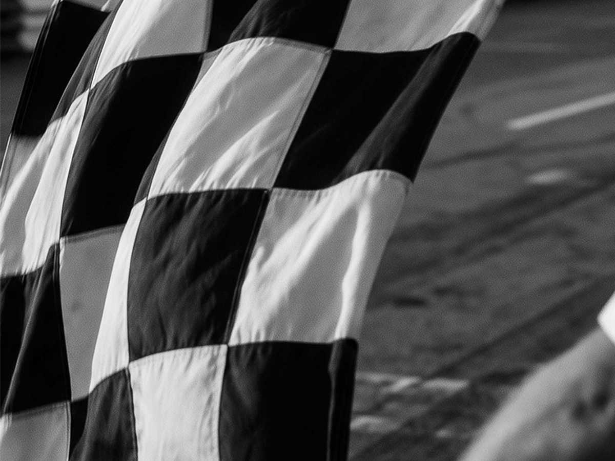 Close-up of a chequered flag waving as a Formula 1 car crosses the finish line at Spielberg