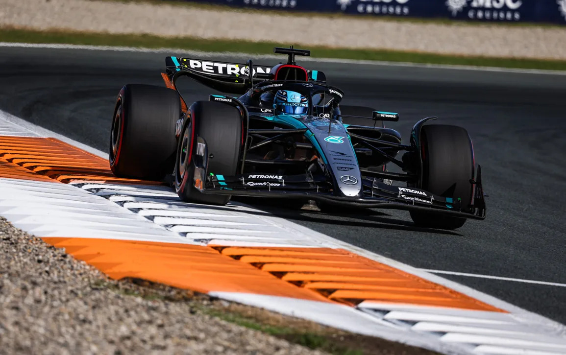 Front-facing shot of a car negotiating a steeply banked corner at Zandvoort at high speed