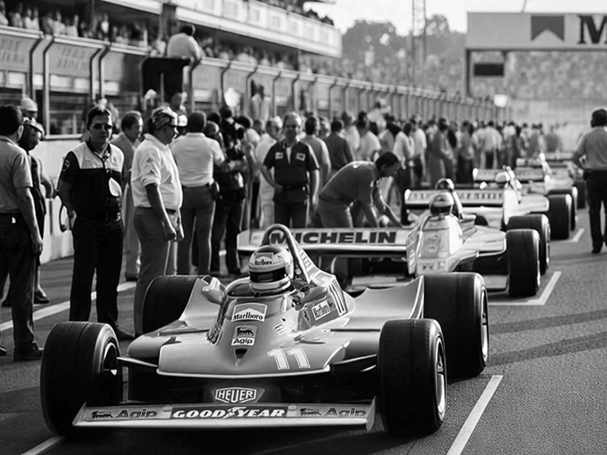 Close-up of front-row cars at Suzuka with drivers poised and mechanics retreating, conveying palpable pre-race tension