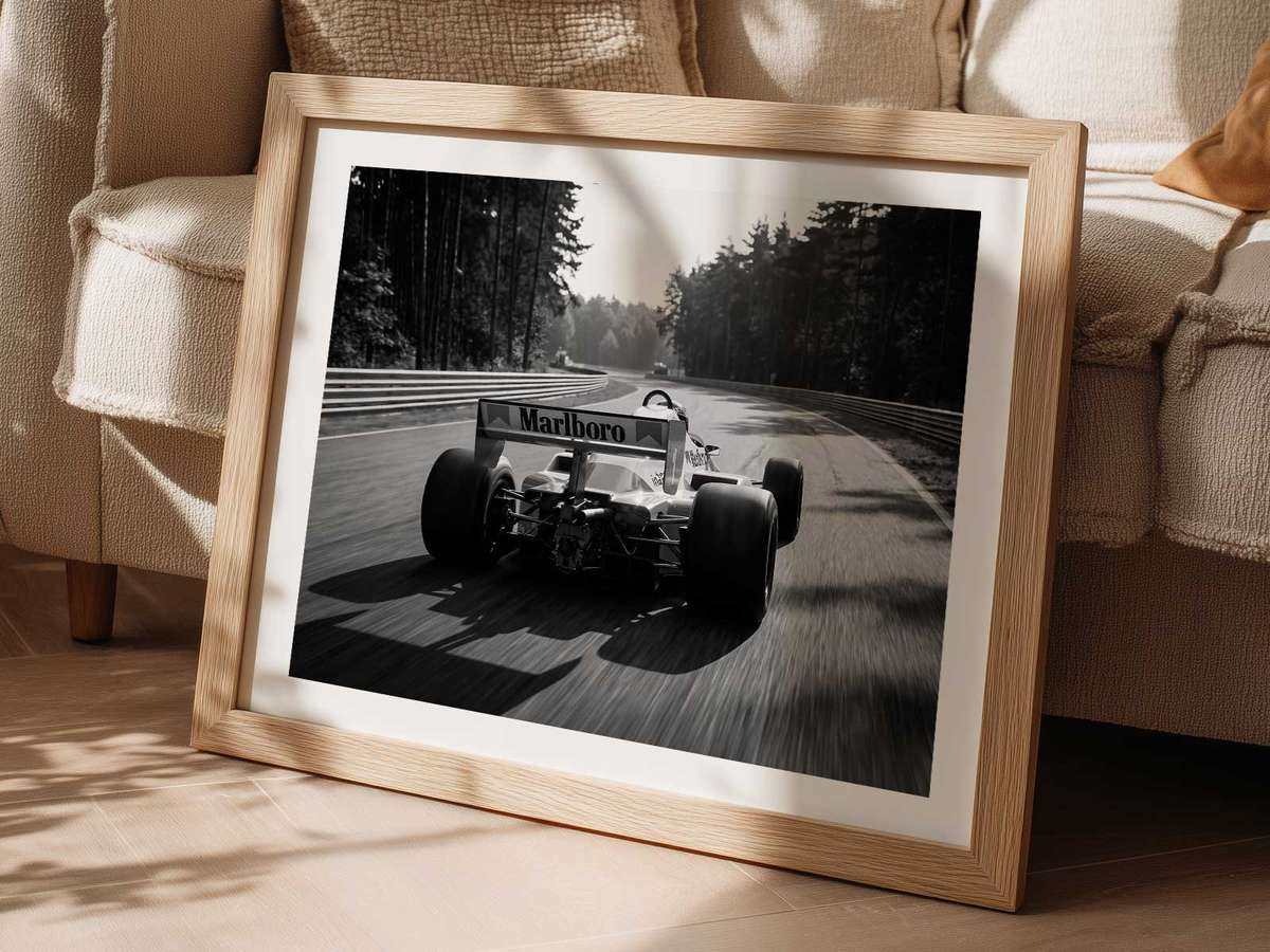 Side profile silhouette of a 1980s McLaren MP4 in iconic red and white livery against a minimalist neutral background