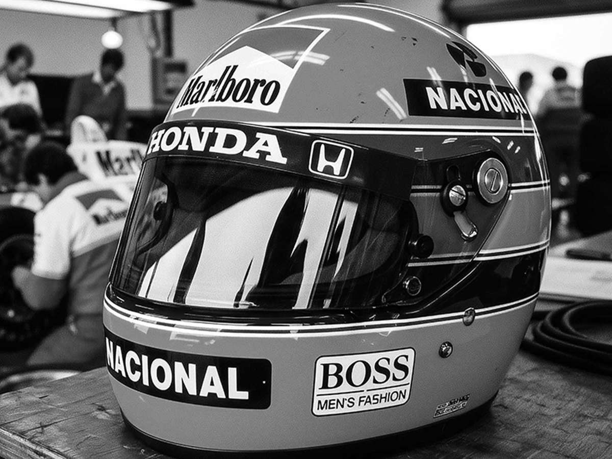 Close-up poster of an iconic racing helmet in spotlight, with textured paint and subtle sponsor decals