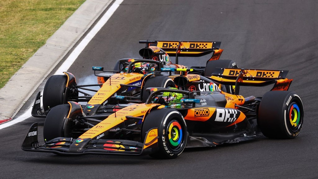 Close-up of a Formula 1 car negotiating a kerb at Imola, showing tyre deformation and chassis load