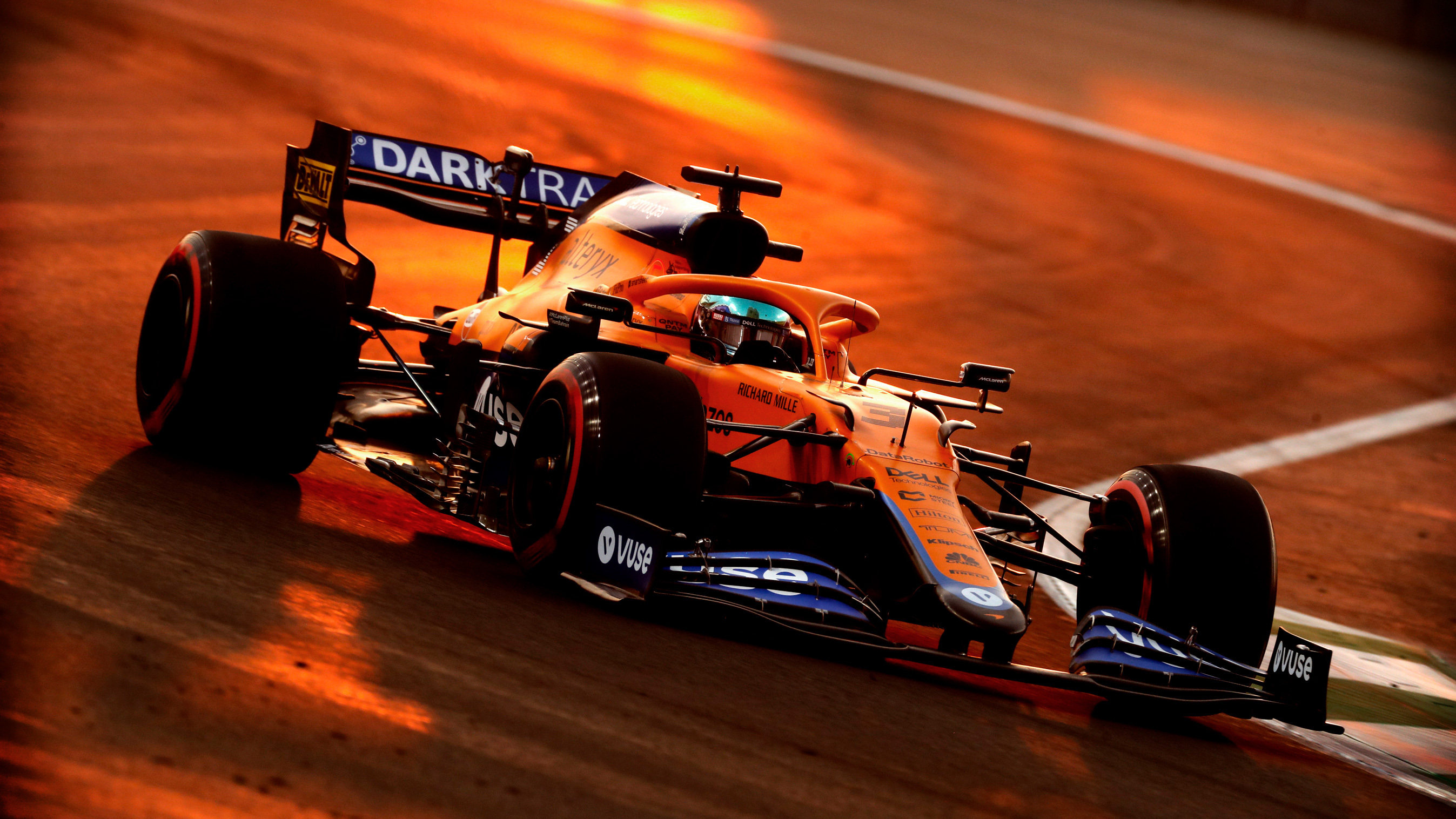 Lando Norris in racing gear at a junior academy event, representing modern driver development