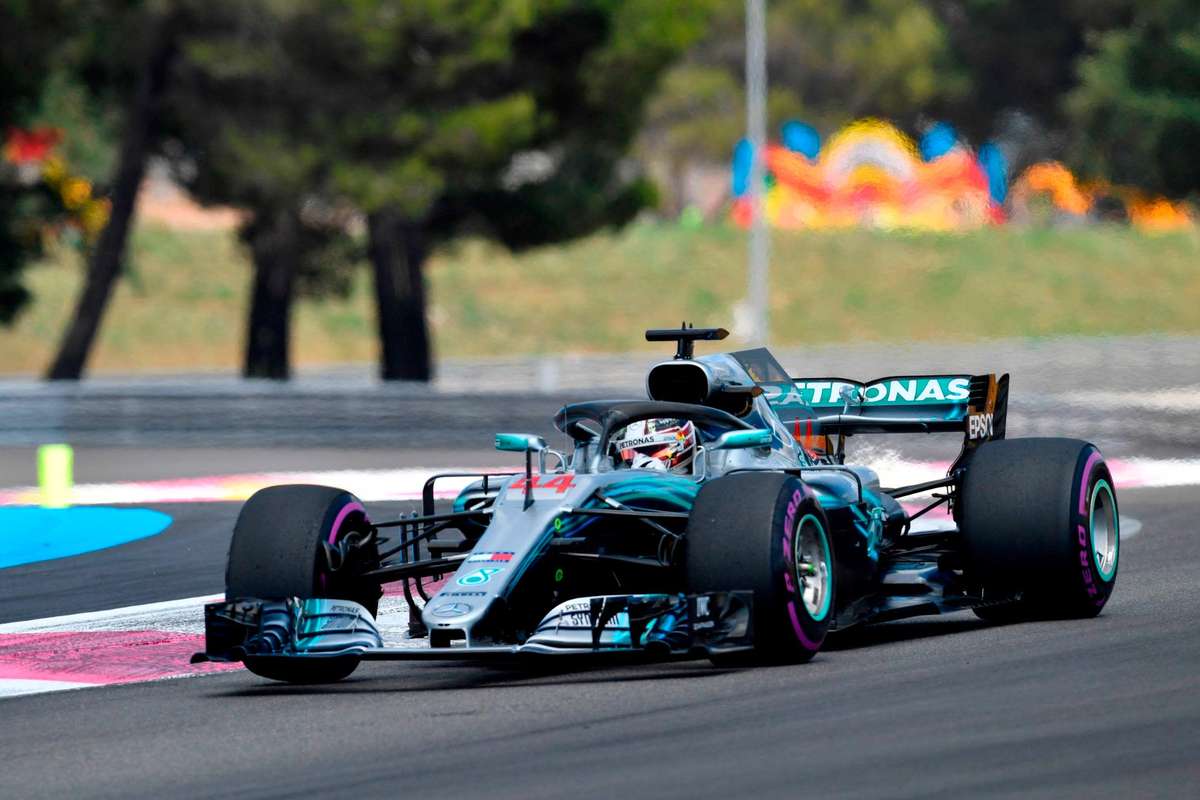 Lewis Hamilton executing a late-braking overtake into a tight corner