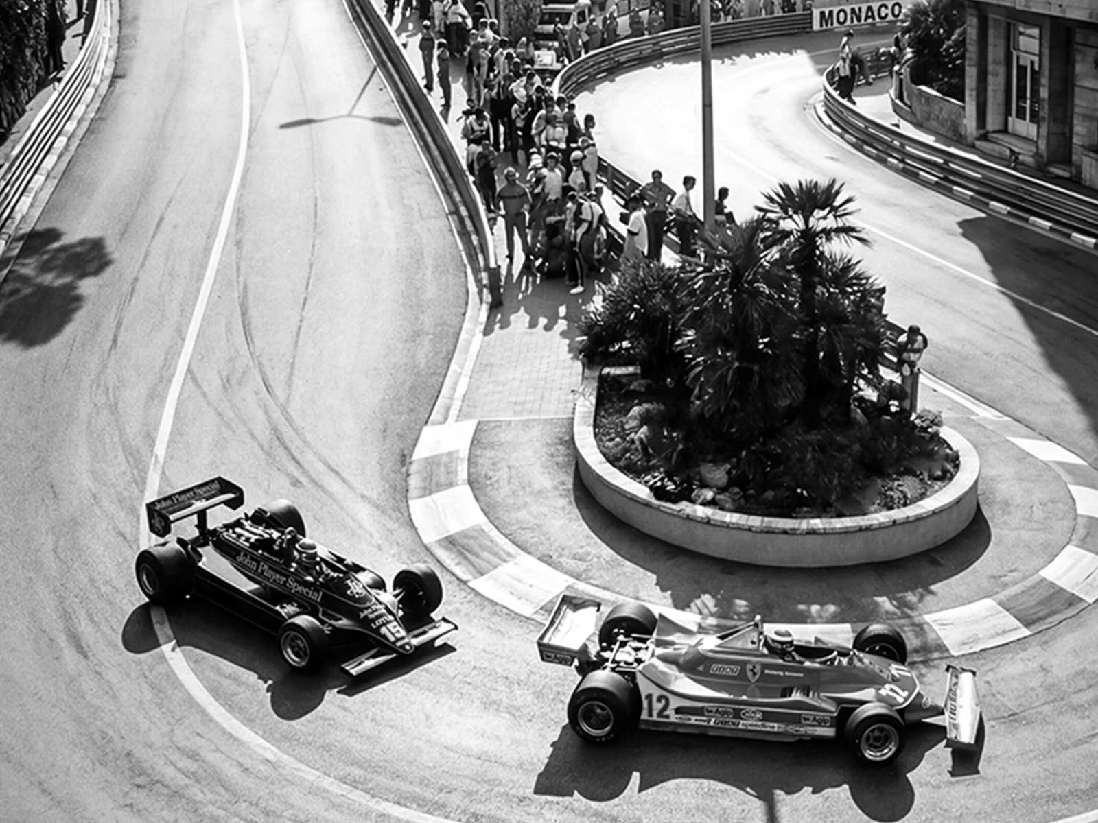 Multiple F1 cars jammed into a tight hairpin with spectators and walls close by, the image conveying pressure and a…