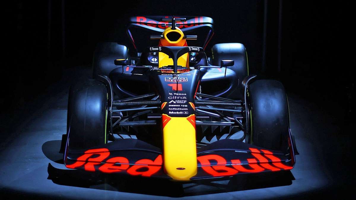 Red Bull F1 car negotiating Eau Rouge and the fast Kemmel straight with spray from damp track