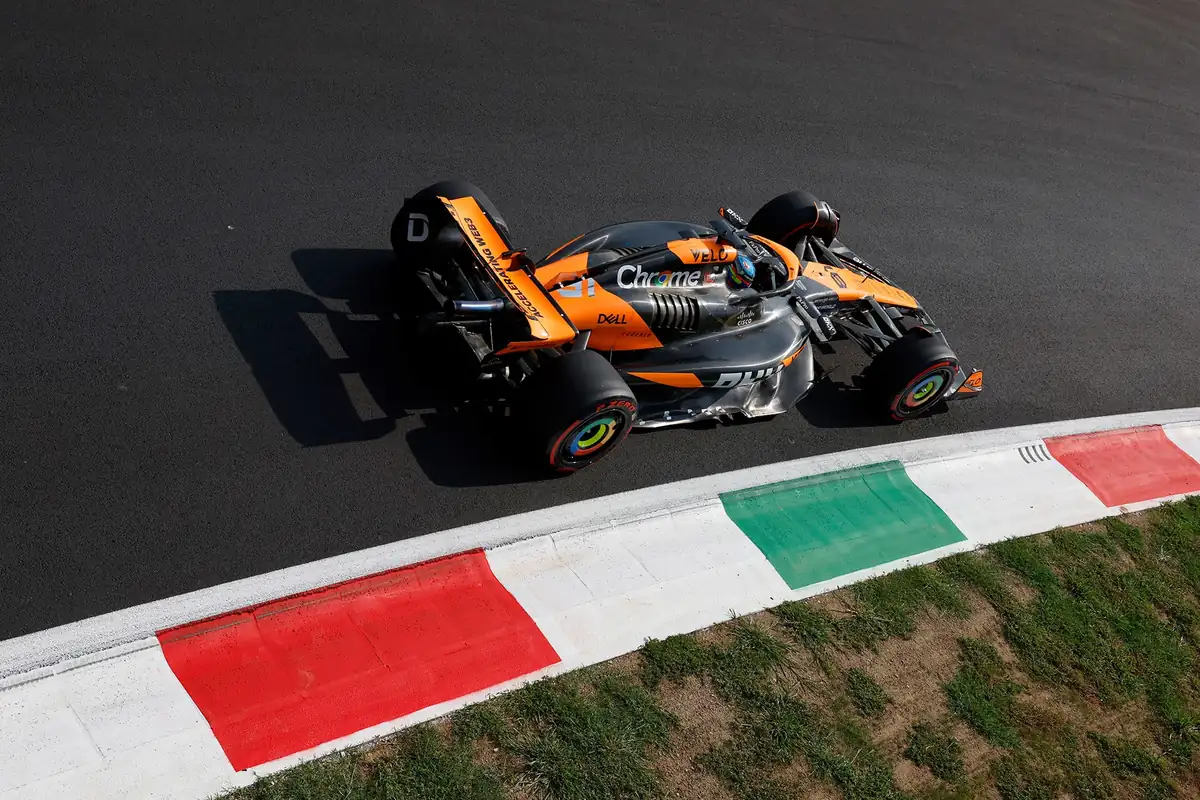 Two Formula 1 cars negotiating the Lesmos with spray from braking and visible slipstream